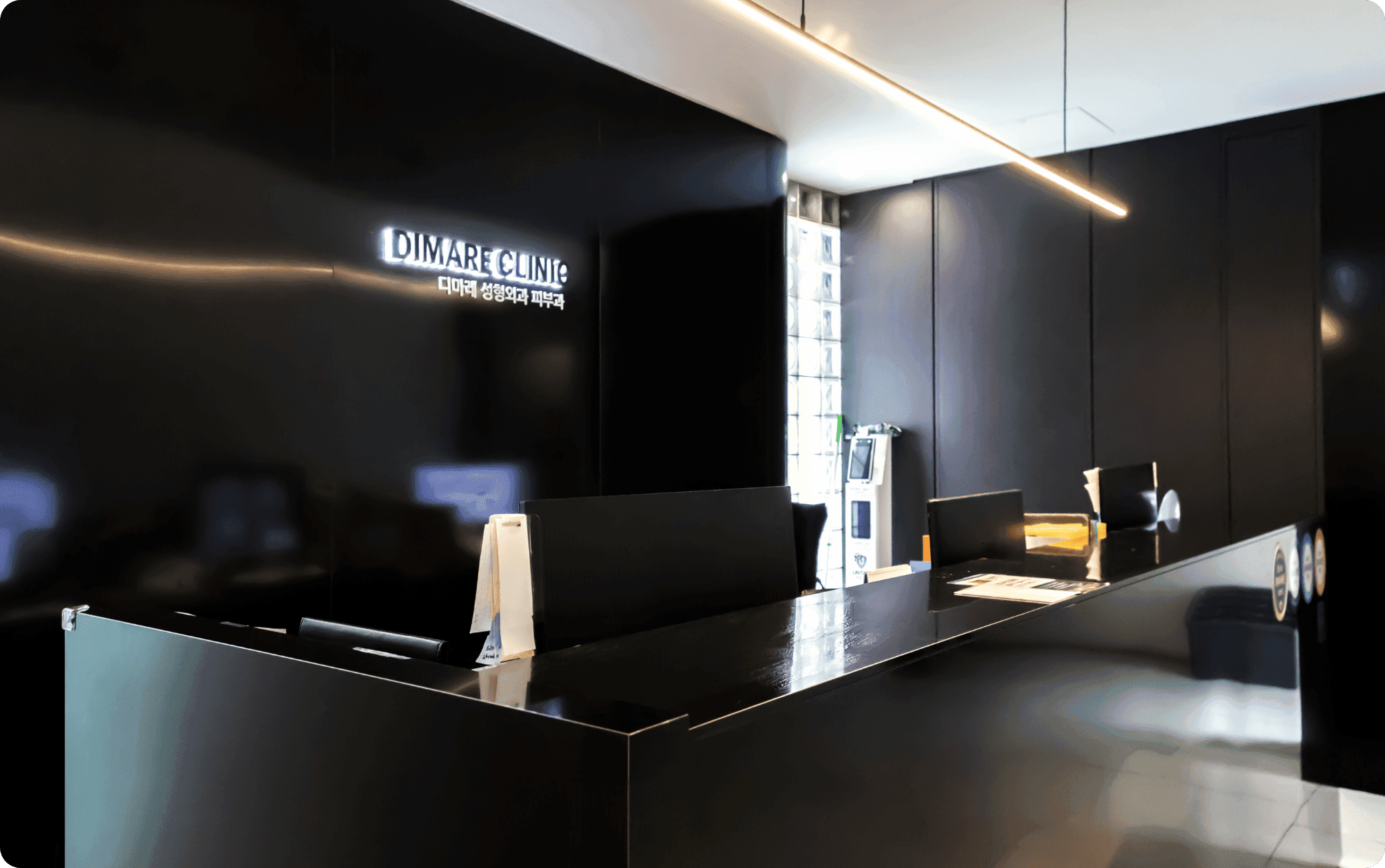 디마레클리닉 내원 접수 및 안내 데스크, 환자를 맞이하는 모던한 블랙 톤의 병원 로비 전경